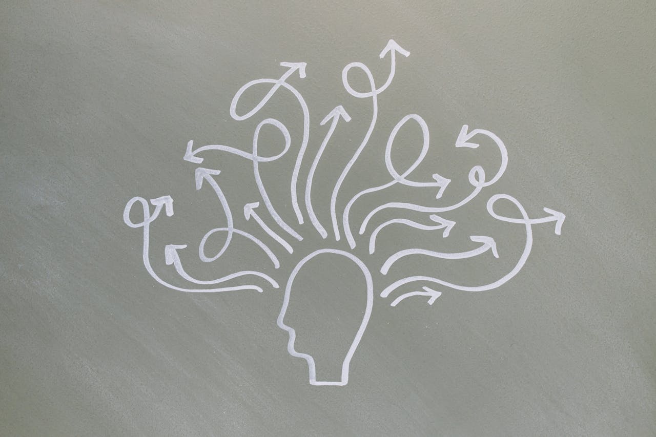 Conceptual chalk drawing illustrating mental health challenges with arrows representing thoughts.